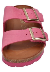 Sandale en suède rose avec deux sangles réglables, boucles dorées et semelle en liège. Semelle plate avec un motif texturé autour du bord.