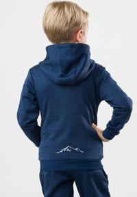Mörkblå hoodie med en texturerad yta, som har en berggrafikdetalj på den nedre delen av ryggen och en kängurufickdesign.