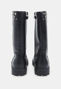 Stivali neri in pelle fino al ginocchio con una finitura opaca, caratterizzati da borchie decorative a forma di cuore lungo il lato esterno e una suola spessa.