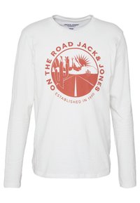 Pitkähihaisen valkoisen T-paidan materiaali on puuvillaa. Siinä on suuri punainen graafinen kuva kaktuksista ja auringosta, jonka ympärillä on teksti "ON THE ROAD JACK & JONES" pyöreässä muodossa.