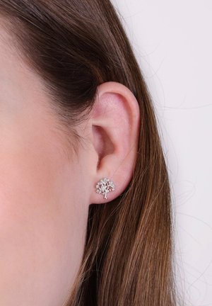 Zilveren boomvormige studoorbel versierd met kleine heldere rhinestones, met een gestructureerde stam en gedetailleerde bladvormen.