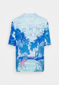 Camisa de manga corta con un estampado tropical azul, que incluye palmeras, pájaros y un flamenco rosa. Tejido suave, ajuste relajado.