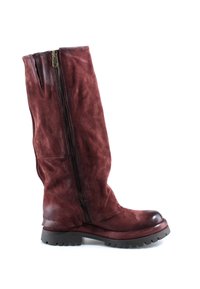 Botte haute en cuir rouge foncé avec fermeture éclair latérale et semelle en caoutchouc noire épaisse, vue de côté sur fond blanc.