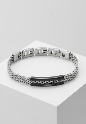 Silver metal bracelet with interlinked chains, featuring a smooth black accent and a clasp with the brand name "BREIL."