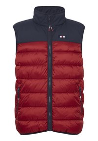 Gilet matelassé rouge et marine avec un design à côtes verticales, col montant, fermeture éclair frontale et deux poches latérales zippées. Il comporte un patch logo.