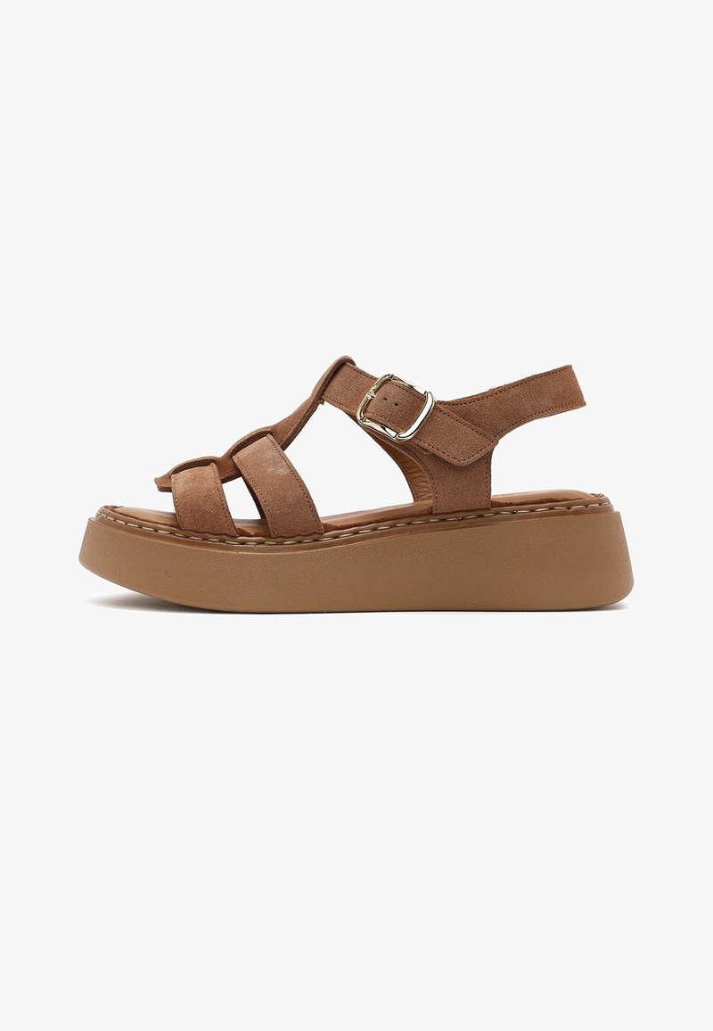Brown platform sandal with three straps, adjustable silver buckle, and thick cushioned sole, shown from the side on a white background.