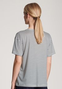 Gestreept T-shirt van lichte stof, met horizontale zwarte strepen op een witte achtergrond, korte mouwen en een ronde halslijn.