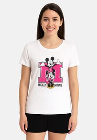 T-shirt bianco in cotone con una grafica colorata di Mickey e Minnie Mouse, accompagnata da uno sfondo rosa oversize con la lettera "M". Maniche corte e scollatura rotonda.