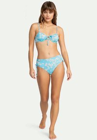 Μπλε μπικίνι σετ με λουλουδάτο σχέδιο, περιλαμβάνει λεπτομέρεια με φιόγκο στην κορυφή και ρυθμιζόμενες πλευρικές κορδόνες στο κάτω μέρος. Απαλή υφή υφάσματος.