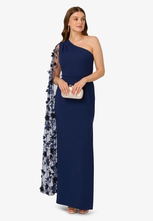 Abito da sera blu navy con design a spalla unica, caratterizzato da un delicato strato trasparente con motivo floreale e una vestibilità aderente. Accompagnato da una pochette argentata.