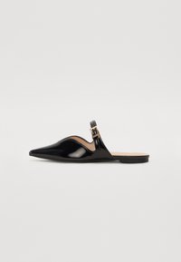 Chaussure slingback en cuir verni noir avec un bout pointu et des découpes arrondies, ornée d'une boucle en métal doré sur la sangle. Semelle plate.