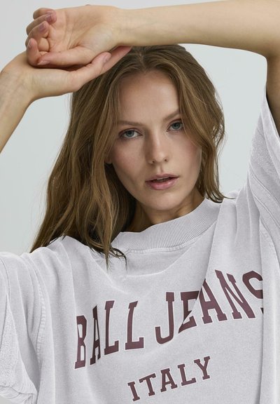 Tricou alb oversized cu inscripția "BALL JEANS ITALY" imprimată în nuanță de vișiniu. Dispune de un guler rotund și mâneci scurte, fiind fabricat dintr-un material texturat.