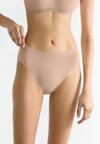 Beige nahtlose Baumwollmix-Unterwäsche mit mittlerer Bedeckung, die eine glatte Textur und eine hohe Taille aufweist. Keine sichtbaren Beschläge.