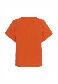 Oranžový krátky rukáv top z texturovanej tkaniny so voľným strihom; má zhrnutý výstrih a široké rukávy pre pohodlný pohyb.