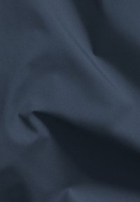 Navyblauwe stof met een gladde textuur, met subtiele deukjes en een zachte glans. Het materiaal lijkt lichtgewicht en flexibel.