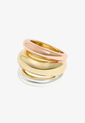 Tre anelli impilabili: uno in oro rosa, uno in oro giallo e uno in argento. Finitura liscia e lucida con forme arrotondate e larghezze variabili.