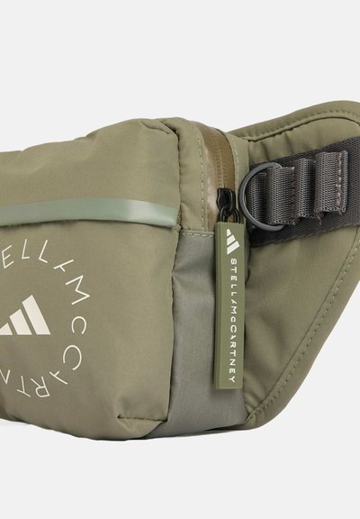 Green nylon fanny pack with a rounded shape, featuring a front zipper, logo print, and adjustable strap with hardware accents.