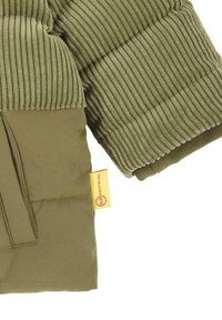 Doudoune verte olive avec des manches côtelées, tissu lisse, poche latérale et étiquette de marque cousue en jaune.