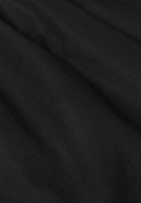 Schwarzer Stoff mit sanften, subtilen Falten und einer glatten, matten Textur.