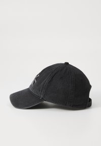 Black denim baseball cap with a curved brim, embroidered logo on the front, and adjustable strap at the back. Textured finish.