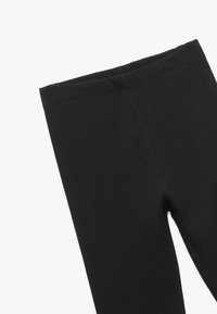 Svarta ribbade leggings med en mjuk textur, med en elastisk midja och en figurnära design, lämpliga för vardagsbruk eller aktiv sport.