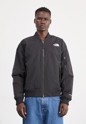 Veste aviateur noire avec fermeture éclair à l'avant, poignets et ourlet côtelés, logo sur la poitrine, poches latérales et tissu texturé. Conception légère et ajustée.