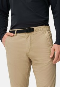 Beige leichte Hose mit elastischem Bund, schwarzem Schnallenverschluss und Seitentaschen, mit glatter Textur und maßgeschneiderter Passform.