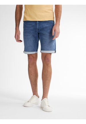 Shorts di denim blu medio con risvolti, abbinati a sneakers bianche con lacci. Il tessuto presenta una classica texture lavata.