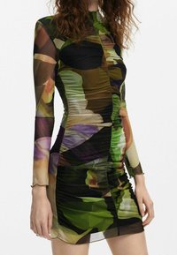 Robe courte à manches longues en tissu extensible et transparent avec un motif floral abstrait multicolore ; détails froncés sur les côtés.