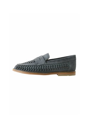 Grey suede loafer with woven detailing along sides and vamp, tan flat sole, slip-on style, viewed from the side against a white background.