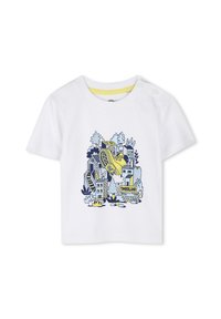 Camiseta de algodón blanca con un diseño gráfico azul y amarillo de una bota entre edificios y árboles ilustrados. Cierres de botón a presión en el hombro.
