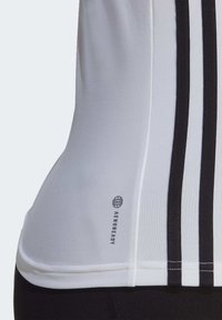 Biała koszulka sportowa z czarnymi paskami po bokach, dopasowany krój, gładka tekstura i logo Aeroready na dolnym wykończeniu.