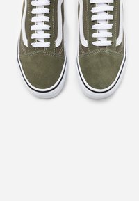 Groene suede sneakers met witte veters, met een klassiek ontwerp, zwarte accenten en een witte rubberen zool. Rond neu en vlak profiel.