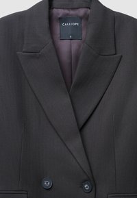 Blazer grigio scuro con motivo a spina di pesce, colletto a punte, due bottoni frontali e rivestimento interno in satin con etichetta.