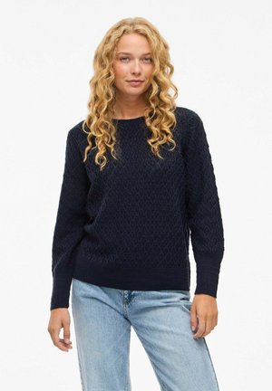 Pull en tricot bleu marine avec un motif en losanges texturé, poignets et ourlet côtelés. Coupe décontractée, encolure ronde et manches longues.