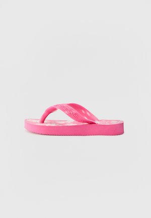 Sandale en mousse rose en caoutchouc, dotée d'une semelle intérieure texturée avec un logo, de fines lanières et d'une semelle plate.