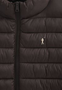 Svart pufferväst med kviltad design, dragkedjeslutning fram och en liten broderad logotyp. Materialet ser jämnt och lätt ut.