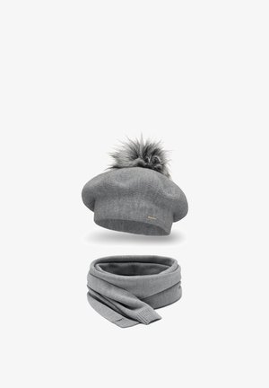 Berretto grigio in lana con pompon in pelliccia sintetica, abbinato a una sciarpa coordinata con bordi a coste e una finitura morbida e testurizzata.