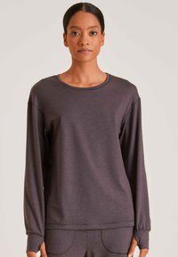 Langsleeve pullover met ronde hals in donkergrijze stof met een gladde textuur. Kenmerkt zich door een ontspannen pasvorm en ribgebreide manchetten.
