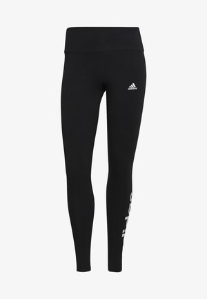 Sorte træningsleggings med højt talje, prydet med et hvidt Adidas-logo på den øvre del af benet og et vertikalt hvidt tekstdesign på den nederste del af benet.