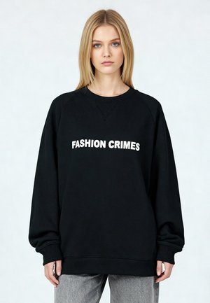 Felpa nera con la scritta "FASHION CRIMES" in bianco, caratterizzata da scollo a girocollo, maniche raglan lunghe e polsini e orlo a costine.