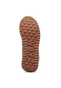 Schuhsohle aus braunem Gummi mit sternförmigem Profil, beinhaltet den Text "W6YZ." Der obere Teil besteht aus grauem Textil- und Wildledermaterial.