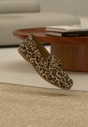 Schuh mit Leopardenmuster, flacher, runder Spitze, weichem Material und hellbraunen Schnürsenkeln. Verfügt über ein niedriges Profil und eine strukturierte, flexible Sohle.