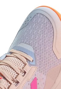 Chaussure de sport légère avec une tige en mesh texturé dans des tons de rose et gris clair, avec des accents orange contrastants et une fermeture à lacets.