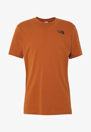 Koszulka z krótkim rękawem w kolorze rdzawego pomarańczu z okrągłym dekoltem i małym czarnym logo "The North Face" na górnej lewej części klatki piersiowej.