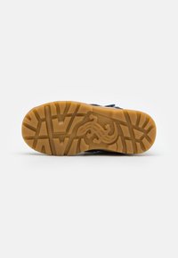 Suela de goma con una superficie texturizada, con un diseño de lagarto y color marrón. Diseñada para proporcionar agarre y durabilidad, con una forma robusta.