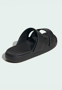 Sort slidesandal med minimalistisk design, der har to brede remme, en kontureret fodseng og en tekstureret sål. Fremstillet af letvægtsmateriale.