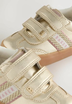 Detské zlaté metalické tenisky s dvojitými suchými zipsami, gumenou podrážkou a ružovým a zlatým pleteným detailom označeným "BAKER."