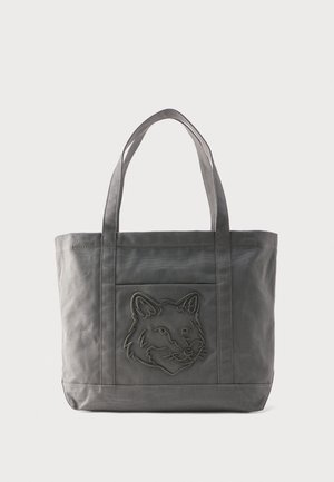 Gray canvas tote bag with two handles and front pocket featuring a stitched wolf head design.