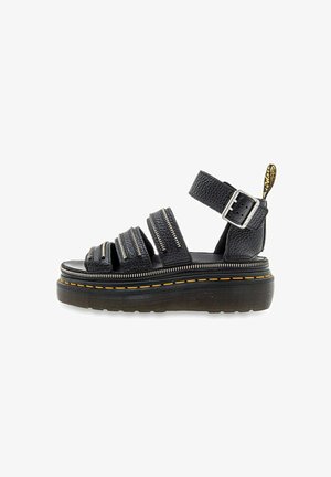 Black leather sandals with multiple thick straps, zipper accents, and adjustable ankle buckle. Features a chunky platform sole with yellow stitching.